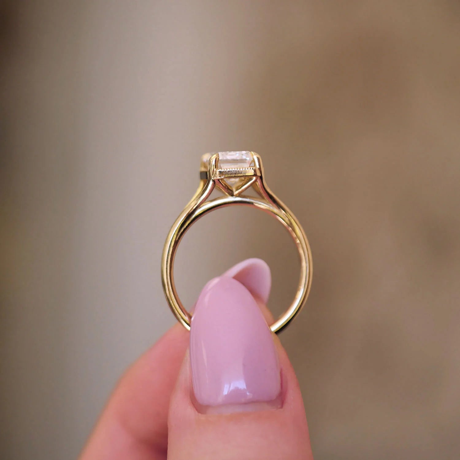 Close-up of Split Shank Emerald Solitaire Ring, yellow gold band